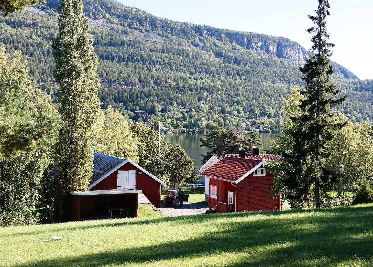 bildet viser et lite gårdstun på Utøya, bildet er tatt i solskinn