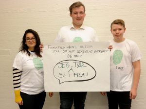 Viser tre ungdommer med en kampanjeplakat