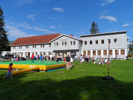 viser Skogstad Leirsted på Eina, ser skolebygget og uteplassen med mange barn og unge ute og leker