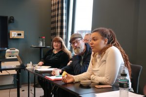 Bildet viser fire personer som sitter ved et møtebord