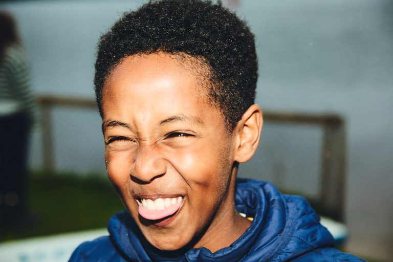 Barn smiler og lager grimaser til kamera